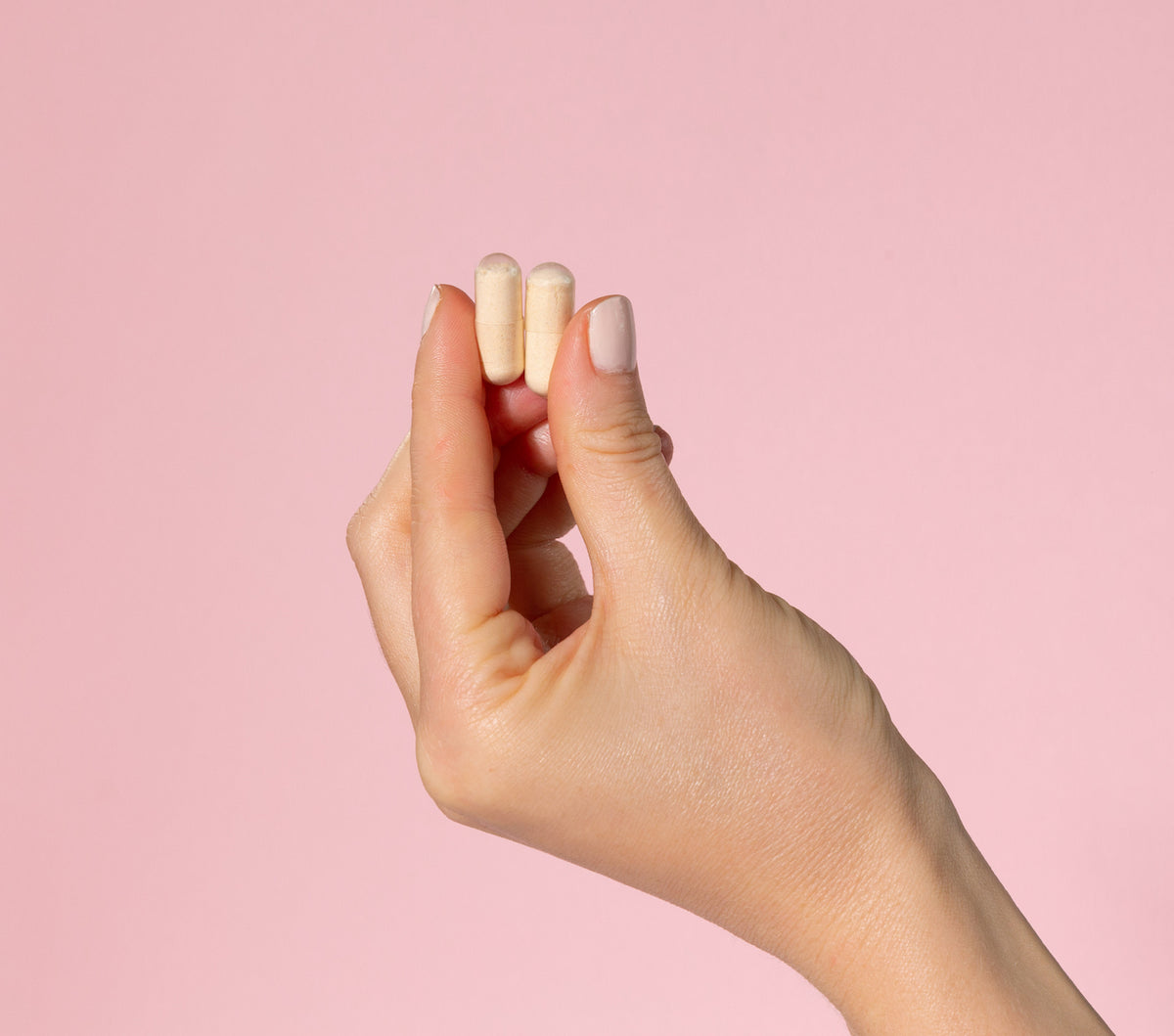 Two pullulan capsules held between finger and thumb